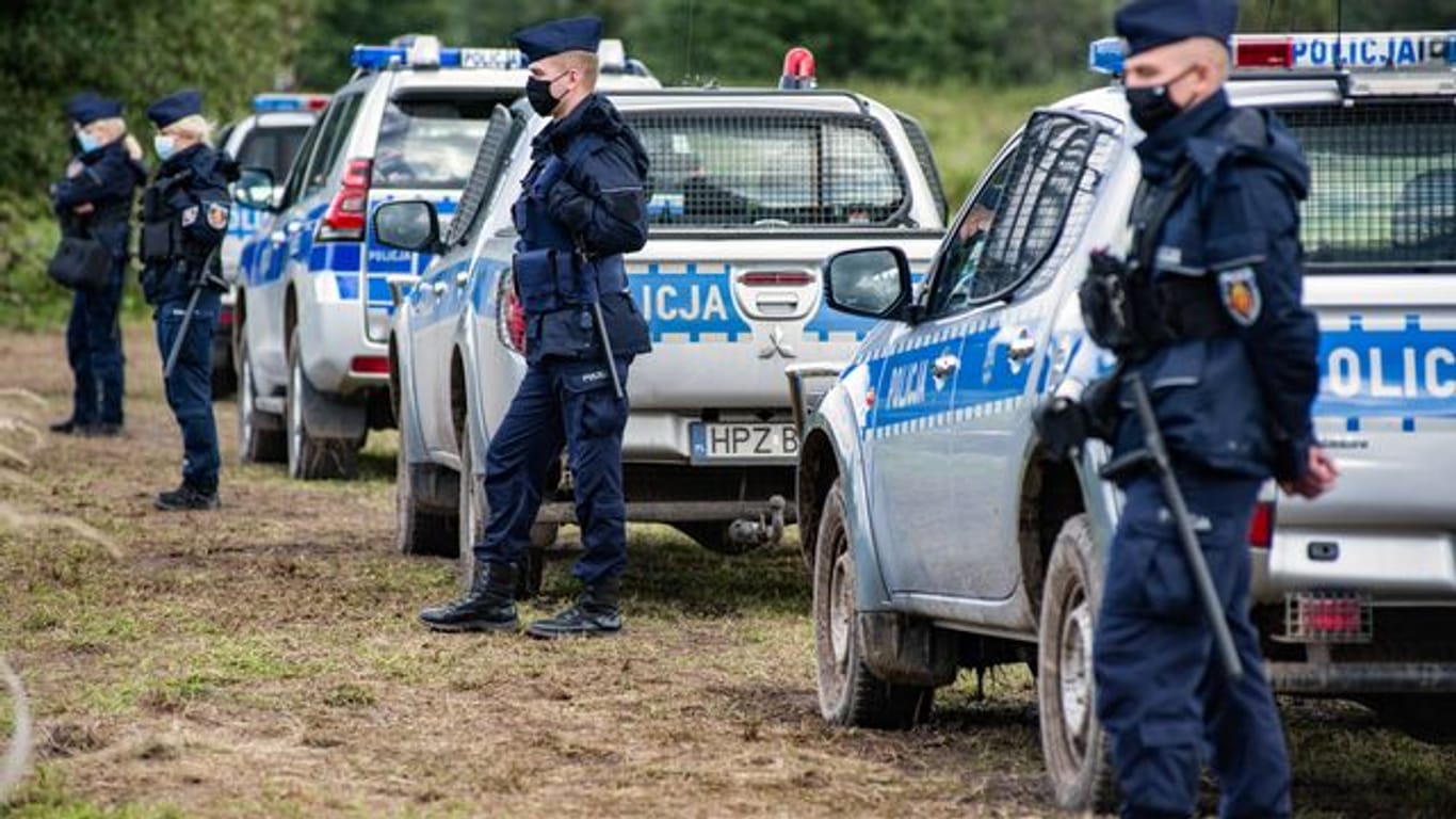 Polizeibeamte stehen an der polnisch-belarussischen Grenze.
