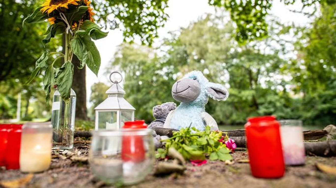 Zwei Stofftiere, Kerzen und Sonnenblumen sind an dem kleinen See in Hamm abgelegt worden.