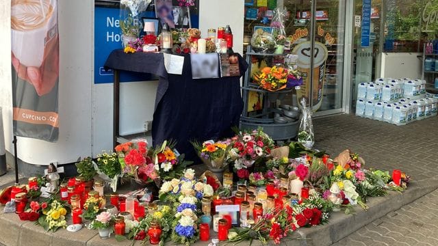 Blumen und Kerzen sind vor der Aral-Tankstelle in Idar-Oberstein aufgestellt.