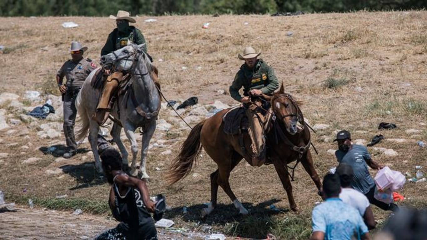 Beamte der US-Zoll- und Grenzschutzbehörde versuchen auf Pferden, Migranten an der Überquerung des Grenzflusses Rio Grande zu hindern.