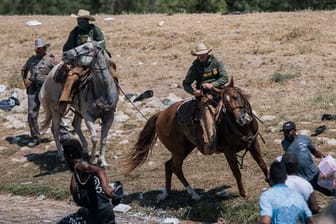 Beamte der US-Zoll- und Grenzschutzbehörde versuchen auf Pferden, Migranten an der Überquerung des Grenzflusses Rio Grande zu hindern.