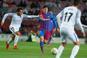 Luis Milla (l) vom FC Granada versucht Yusuf Demir (M) vom FC Barcelona zu stoppen.