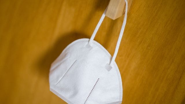 Eine FFP2-Maske hängt an einem Haken.