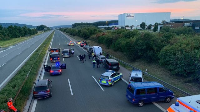 Polizisten und Helfer stehen mit ihren Fahrzeugen auf der Autobahn 9.