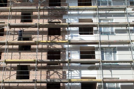 An einem Altbau wird während der Renovierung eine Wärmedämmung an die Fassade angebracht.