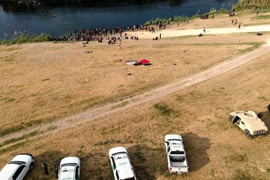 Offizielle Fahrzeuge der US-Grenzkontrolle stehen am Ufer des Flusses Rio Grande in der Nähe eines Lagers von Migranten, viele aus Haiti, nahe der Del Rio International Bridge.
