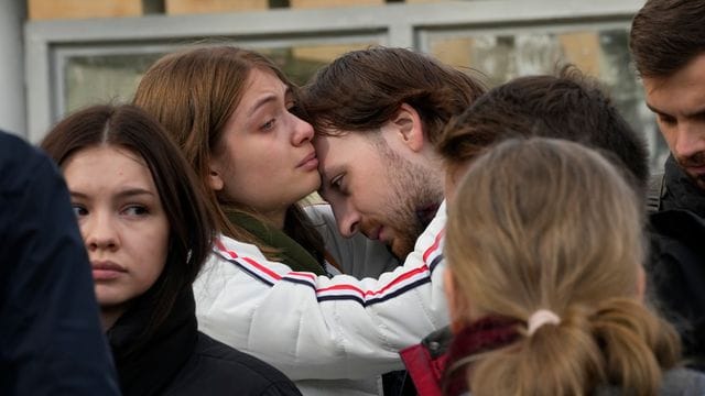 Studenten trösten sich gegenseitig während einer Versammlung nach der Schießerei auf dem Campus der Staatlichen Universität Perm. Studenten trösten sich gegenseitig während einer Versammlung nach der Schießerei auf dem Campus der Staatlichen Universität Perm.