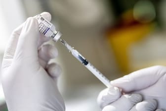 Die Mitarbeiterin eines Impfbusses zieht den Covid-19-Impfwirkstoff Comirnaty von Biontech/Pfizer auf eine Spritze.