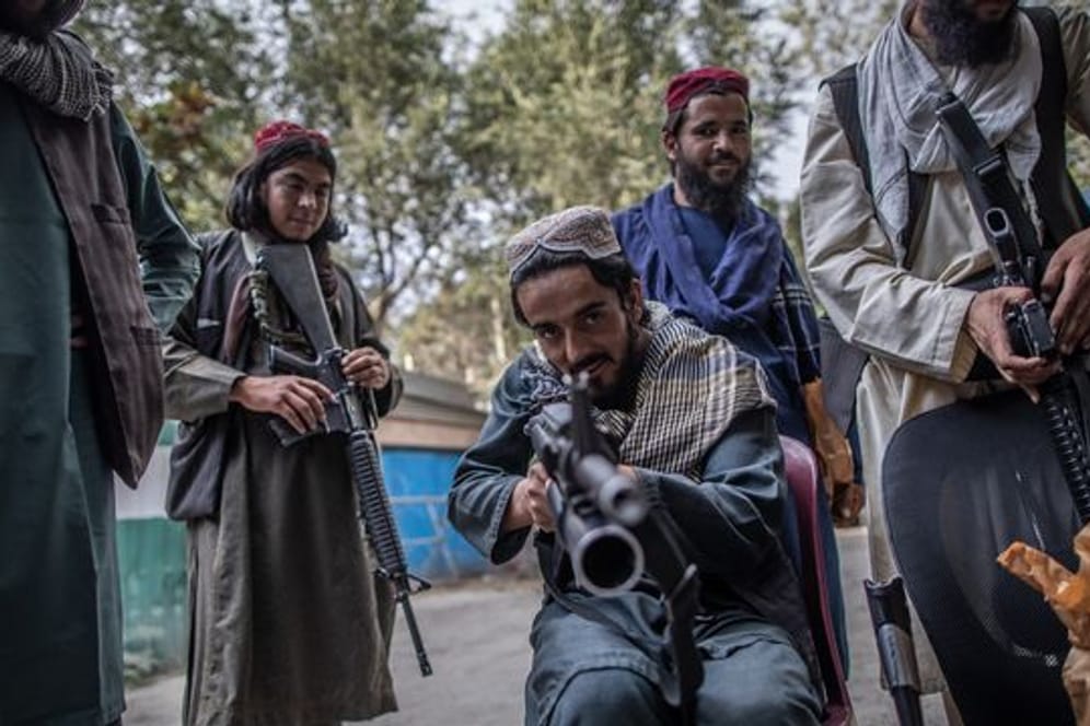 Ein junger Taliban-Kämpfer zielt zum Spaß mit seinem Gewehr in Richtung Fotograf, während er vor einer Polizeistation in Kabul Wache hält.
