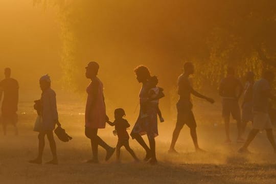 Migranten, viele von ihnen aus Haiti, gehen zu einem improvisierten Flüchtlingslager in Ciudad Acuña.