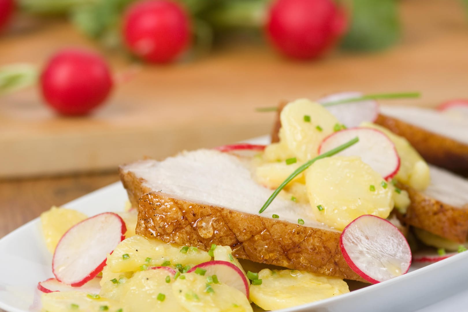 Schweinekrustenbraten: Wer mag, serviert das Gericht mit Kartoffelsalat.