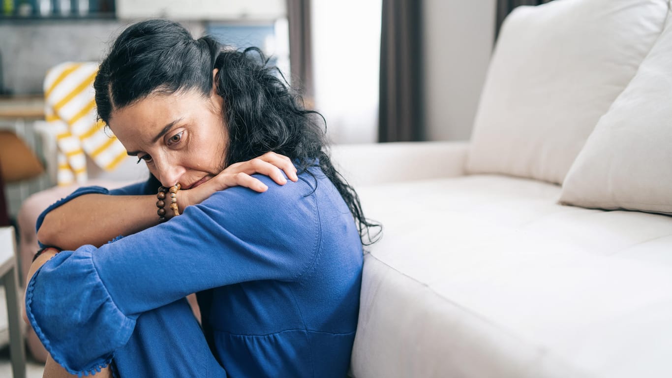 Traurig wirkende Frau: In der depressiven Phase einer bipolaren Störung sind eine niedergeschlagene Stimmung sowie Freud- und Interessenlosigkeit typische Symptome.