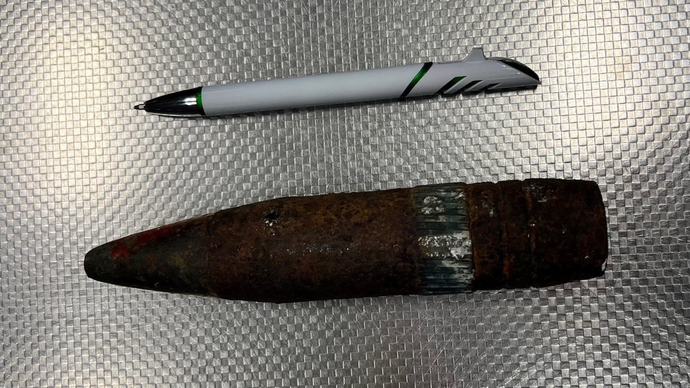 Eine im Reisegepäck eines Fluggastes entdeckte Mörsergranate liegt neben einem Kugelschreiber am Flughafen. Wie die Polizei mitteilte, handelte es sich dabei tatsächlich um eine scharfe und damit lebensgefährliche Kriegswaffe.