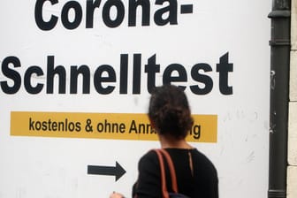 Ein Plakat weist auf eine Corona-Teststation hin (Symbolbild): Mit den Betrugsmaschen soll die Gruppe hohen Schaden verursacht haben.
