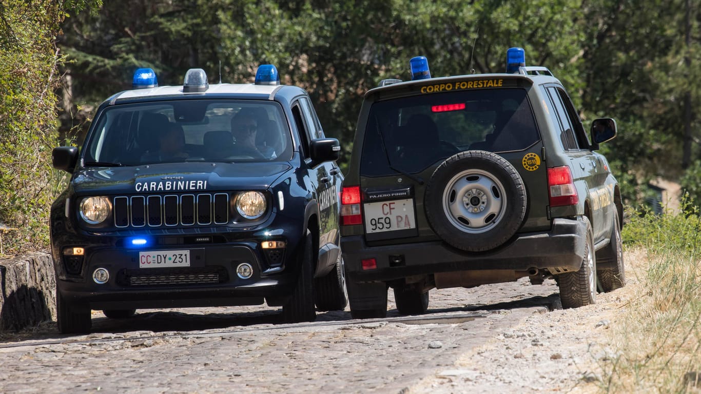 Zwei Polizeifahrzeuge auf einem Waldweg in Sizilien (Archivbild). Eine Großfahndung nach einem Mafiaboss wurde am Freitag erfolglos abgebrochen.