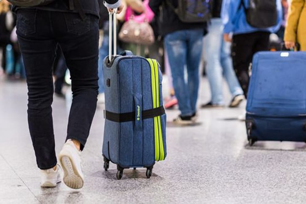 Reisende mit Gepäck stehen im Terminal C vom Flughafen Hannover-Langenhagen (Archivbild): Passagiere müssen oft lange Wartezeiten aushalten.