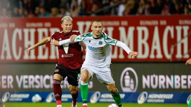 Hannovers Tom Trybull (r) schirmt den Ball vor dem Nürnberger Lino Tempelmann (l) ab. Hannovers Tom Trybull (r) schirmt den Ball vor dem Nürnberger Lino Tempelmann (l) ab.
