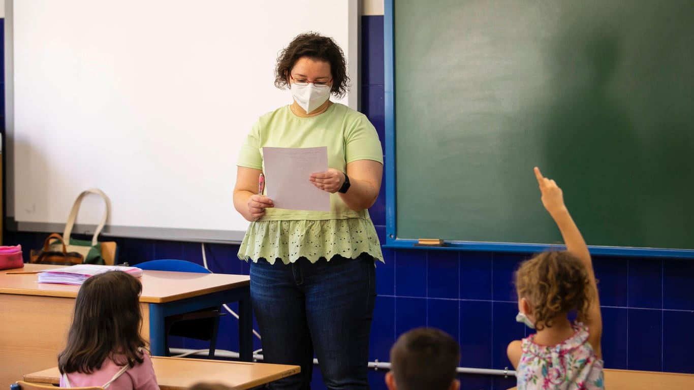 Eine Lehrerin steht vor einer Schulklasse (Symbolbild): An Schulen entfällt die Maskenpflicht für Kinder bis zur sechsten Klasse.