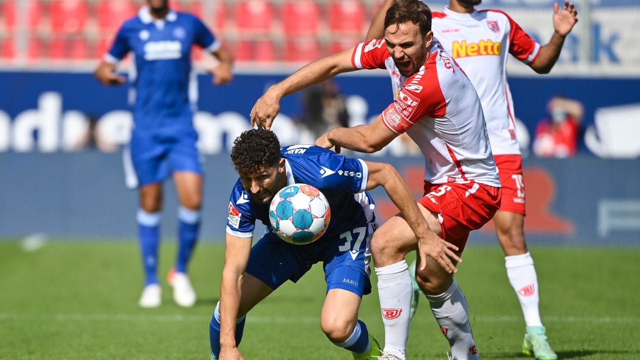 Karlsruhes Fabio Kaufmann (l) versucht den Ball vor Regensburgs Benedikt Gimber zu behaupten. Karlsruhes Fabio Kaufmann (l) versucht den Ball vor Regensburgs Benedikt Gimber zu behaupten.