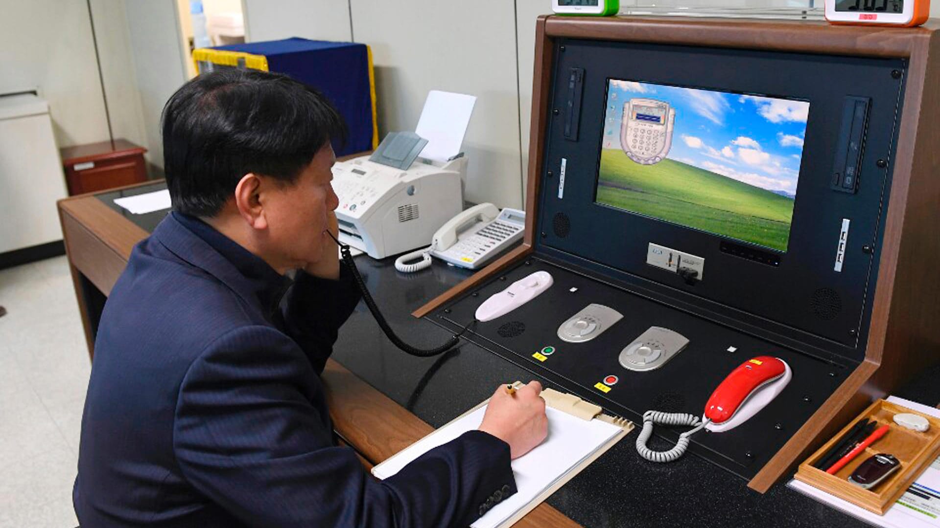 Ein südkoreanischer Regierungsbeamter spricht mit einem mit einem nordkoreanischen Offizier (Archivbild). Nach langer Pause sind die Telefone und Faxgeräte wieder eingeschaltet worden. Ein südkoreanischer Regierungsbeamter spricht mit einem mit einem nordkoreanischen Offizier (Archivbild). Nach langer Pause sind die Telefone und Faxgeräte wieder eingeschaltet worden.