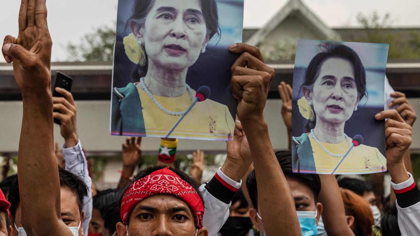 Demonstranten halten bei einem Protest gegen den Putsch Bilder von Aung San Suu Kyi: Die gestürzte Regierungschefin hat offenbar gesundheitliche Probleme.
