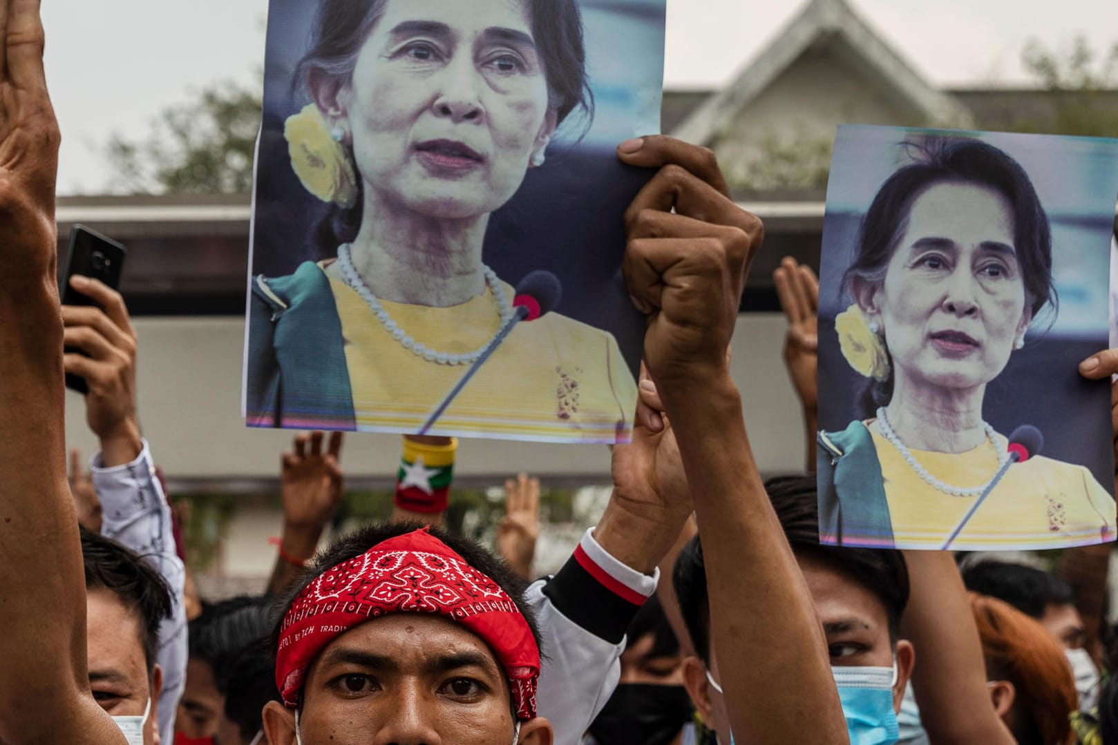 Demonstranten halten bei einem Protest gegen den Putsch Bilder von Aung San Suu Kyi: Die gestürzte Regierungschefin hat offenbar gesundheitliche Probleme.