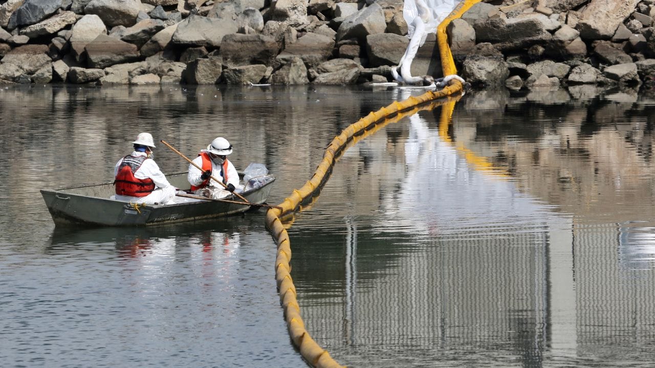 Arbeiter sammeln Öl aus dem Meerwasser in Huntington Beach.