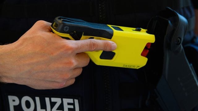 Ein Polizeibeamter präsentiert einen Taser.