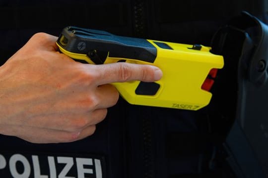 Ein Polizeibeamter präsentiert einen Taser.