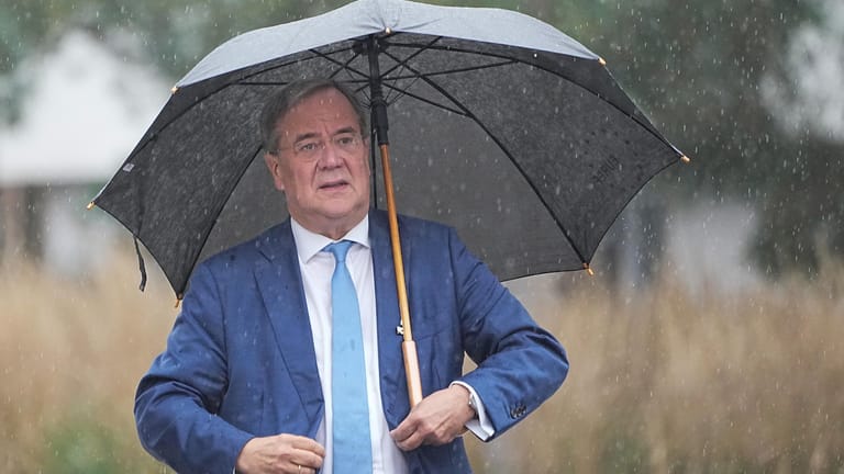 Armin Laschet trifft zu den Sondierungsgesprächen zwischen Union und Grünen im strömenden Regen ein.