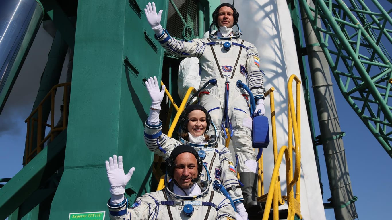 Kosmonaut Anton Schkaplerow (von unten), Schauspielerin Julia Peressild und Regisseur Klim Schipenko vor dem Start neben der Rakete: Zwölf Tage sollen sie im All verbringen.