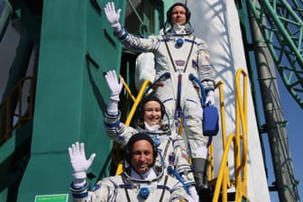 Kosmonaut Anton Schkaplerow (von unten), Schauspielerin Julia Peressild und Regisseur Klim Schipenko vor dem Start neben der Rakete: Zwölf Tage sollen sie im All verbringen.