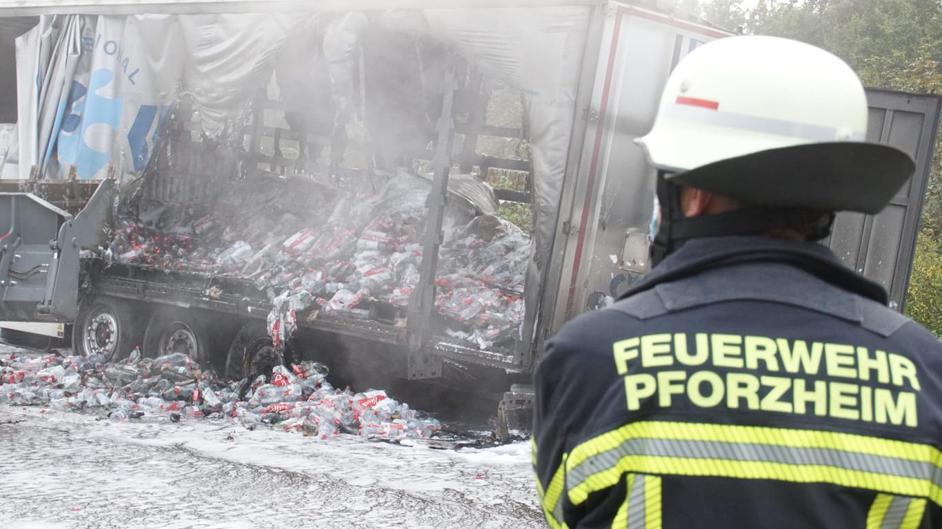 Ein Feuerwehrmann steht vor dem ausgebrannten Sattelauflieger eines Lastwagens auf der Autobahn 8 zwischen Karlsruhe und Stuttgart: Hier sorgt am Dienstagmorgen ein Lkw-Fahrer für Verzögerungen.