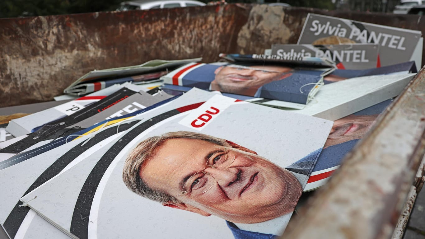 CDU-Wahlplakate zur Bundestagswahl mit dem Bild des Unions-Spitzenkandidaten Armin Laschet liegen vor der Parteizentrale in einem Container zur Entsorgung.
