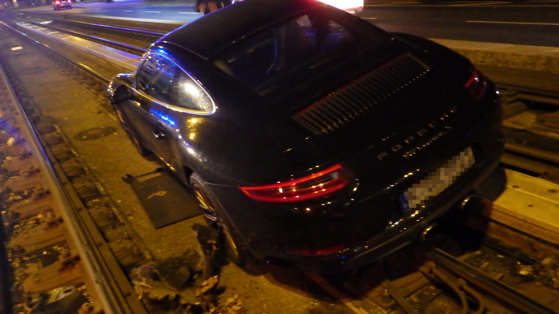 Der im Gleisbett stecken gebliebene Porsche: Der Dieb flüchtete anschließend zu Fuß. Der im Gleisbett stecken gebliebene Porsche: Der Dieb flüchtete anschließend zu Fuß.