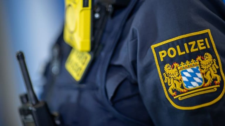 Eine Polizistin trägt ein Abzeichen der bayerischen Polizei (Symbolbild): Ein Mann soll wieder neue, ähnliche Straftaten begangen haben.