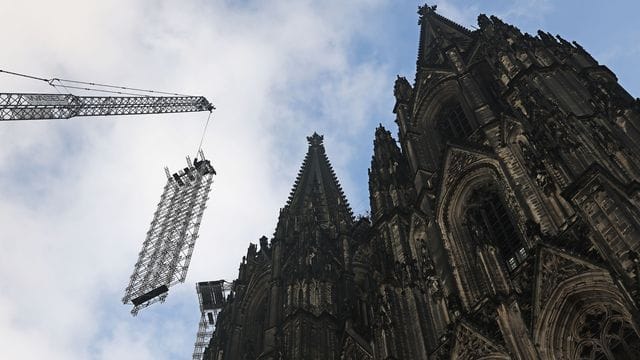Ein Teil des Baugerüstes wird vor dem Dom heruntergelassen.