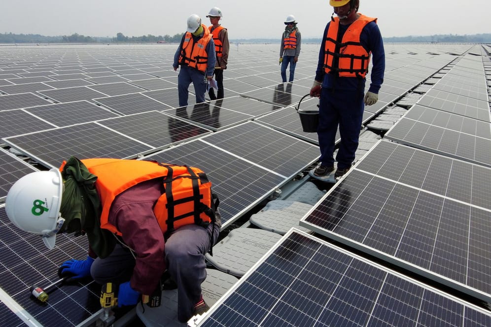 Arbeiter installieren eine Solaranlage: Klimaschutz benötigt große Investitionen.