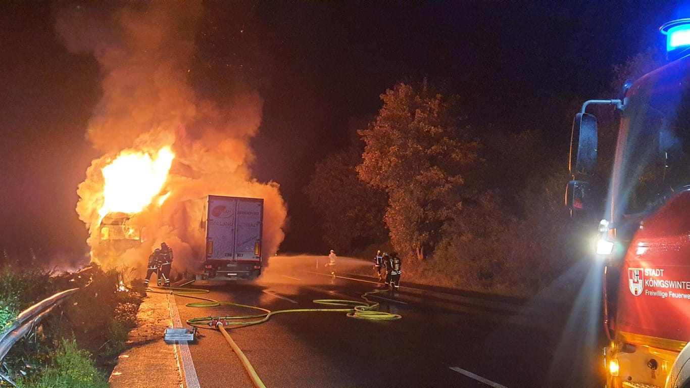 Feuerwehrleute löschen den Brand auf der A3: Die Autobahn war am Donnerstagmorgen wegen des Feuers bei Siegburg vorübergehend gesperrt worden.