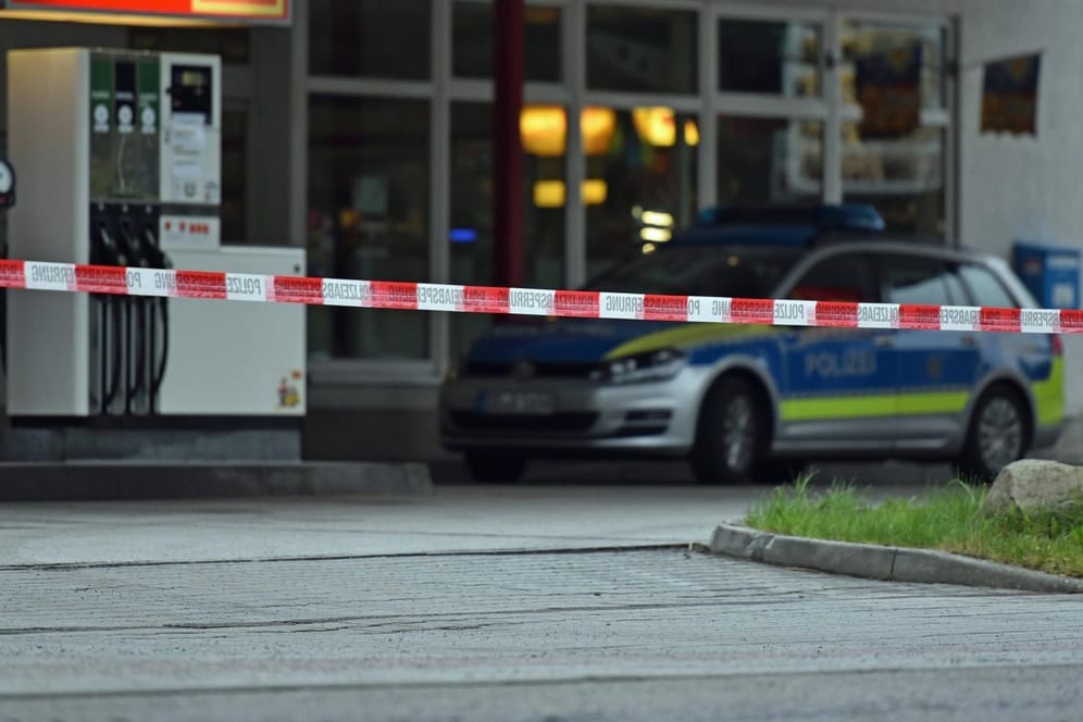 Ein Polizeiauto vor einer Tankstelle (Archivbild): In Mülheim hat eine Frau ohne Maske die Mitarbeiter einer Tankstelle mit dem Tod bedroht.
