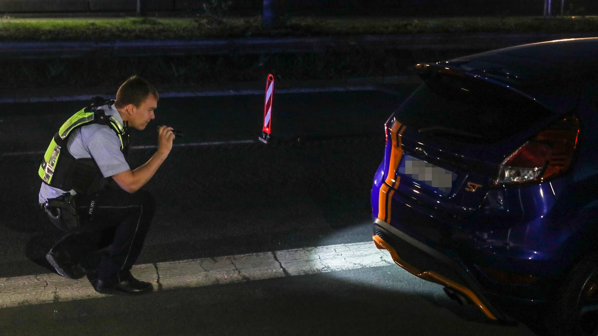 Ein Polizist kontrolliert einen Pkw (Archivbild): In Dortmund haben Zivilbeamte einen aufmüpfigen Raser gestoppt. Ein Polizist kontrolliert einen Pkw (Archivbild): In Dortmund haben Zivilbeamte einen aufmüpfigen Raser gestoppt.