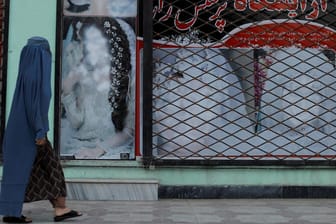 Eine Frau läuft an einem früheren Geschäft vorbei: Die Taliban drängen die Frauen immer weiter aus dem Alltag zurück.