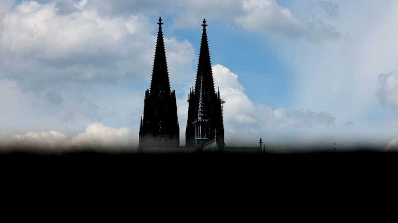 Der Dom in Köln ist hinter einer Mauer zu sehen (Symbolbild): Die Katholische Kirche in der Rheinmetropole befindet sich seit Monaten in einer Krise.