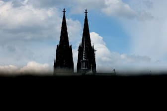 Der Dom in Köln ist hinter einer Mauer zu sehen (Symbolbild): Die Katholische Kirche in der Rheinmetropole befindet sich seit Monaten in einer Krise.