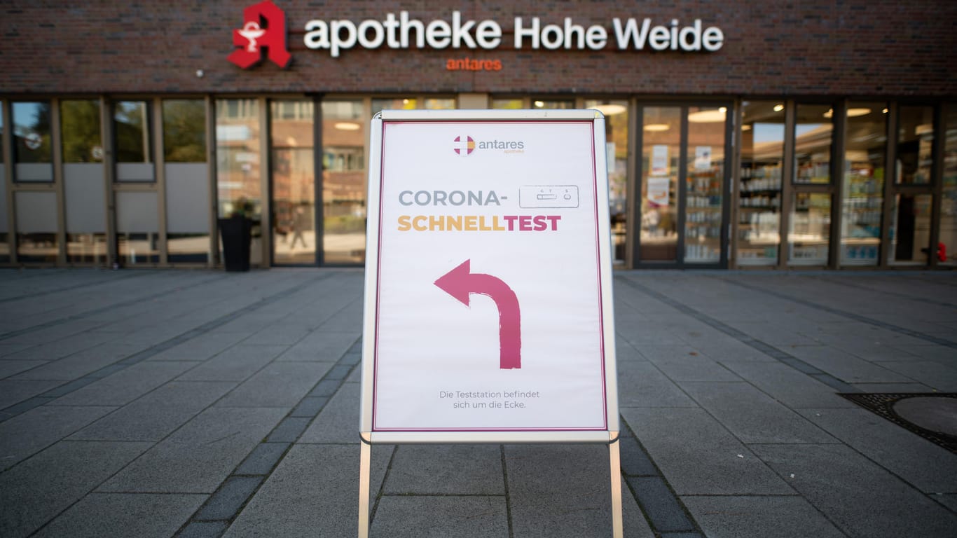 Ein Hinweisschild zu einem Testcenter steht vor einer Apotheke in Hamburg (Archivbild). Viele Ungeimpfte müssen bald bezahlen. Damit sollen sie zum Impfen bewegt werden
