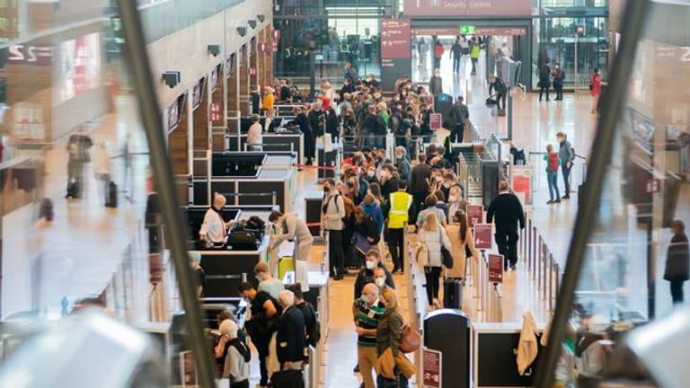 Zahlreiche Passagiere stehen am Flughafen BER im Terminal 1 vor der Sicherheitskontrolle Schlange: Der Andrang zu Beginn der Herbstferien ist groß.