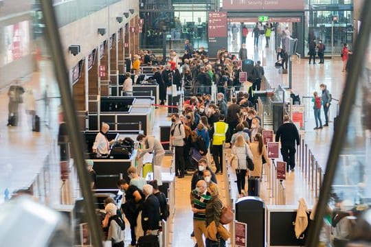 Zahlreiche Passagiere stehen am Flughafen BER im Terminal 1 vor der Sicherheitskontrolle Schlange: Der Andrang zu Beginn der Herbstferien ist groß.