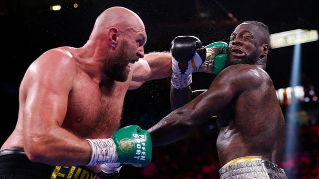 Tyson Fury (l) kann am Kopf von Deontay Wilder einen Treffer landen.