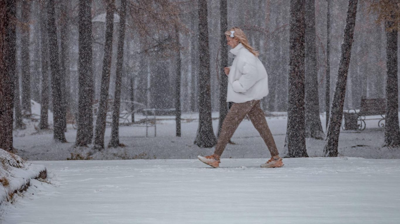 Eine Frau spaziert im Schnee: Nach dem sonnigen Wochenende kommt der Wetterumschwung. (Symbolfoto)