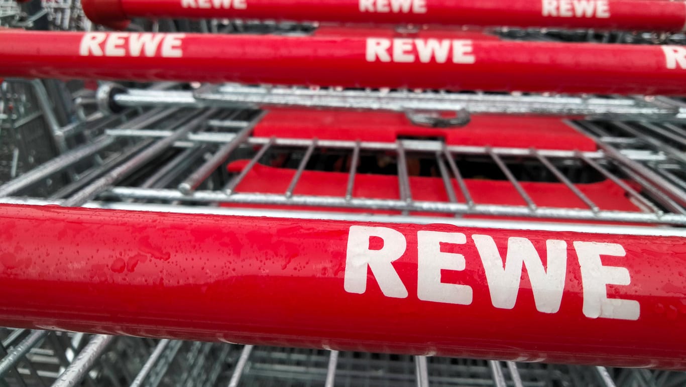 Rewe-Einkaufswagen (Symbolbild): Gegen eine Metzgerei, die das Handelsunternehmen beliefert, gibt es Hygiene-Vorwürfe.